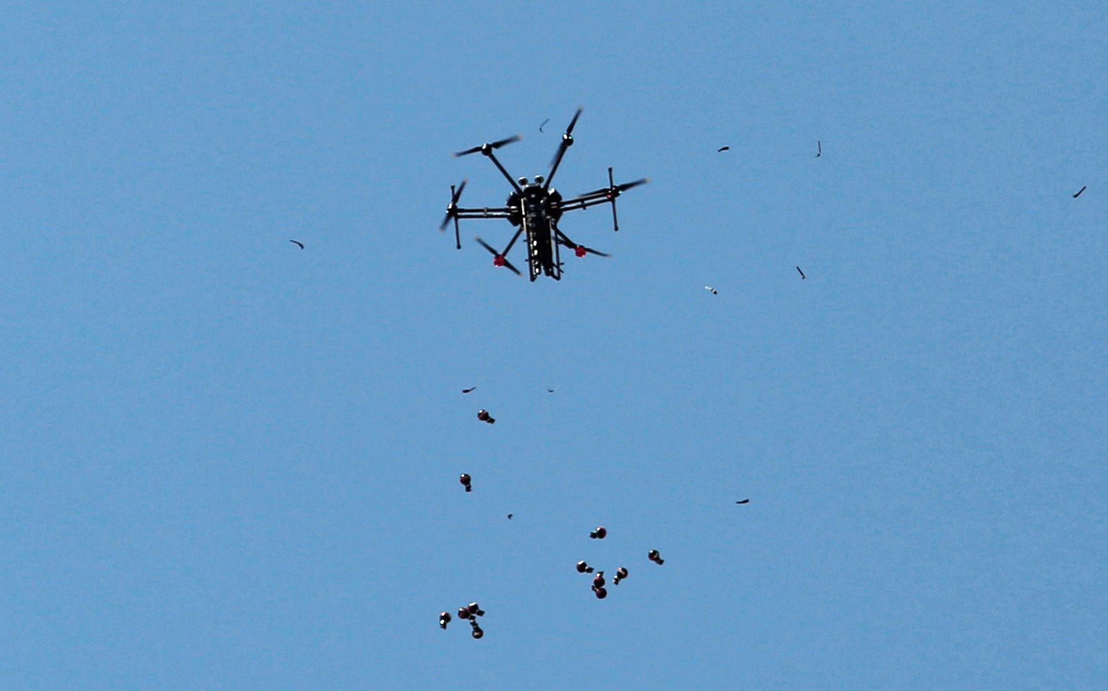 Brezpilotni letalnik, tako imenovani dron, med odmetavanjem ročnih bomb.