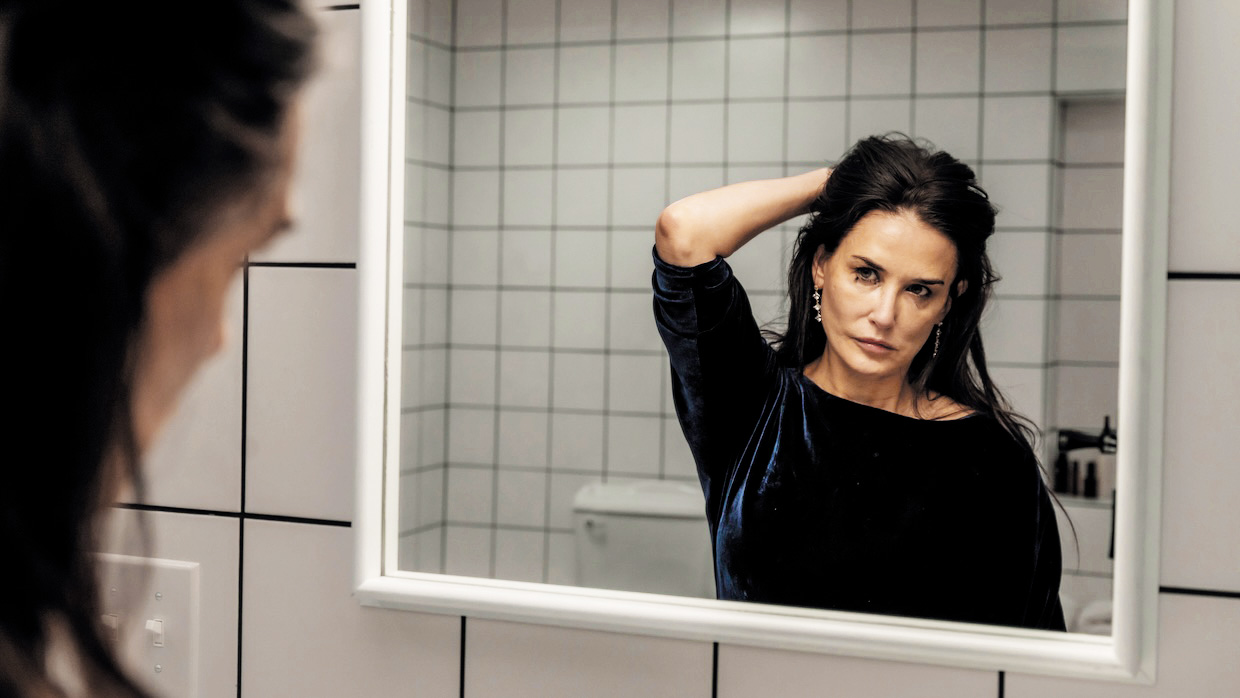 Briljantno grizlijevska Substanca v režiji Coralie Fargeat in z Demi Moore v glavni vlogi je cinična kritika nasprotja opolnomočenja žensk.