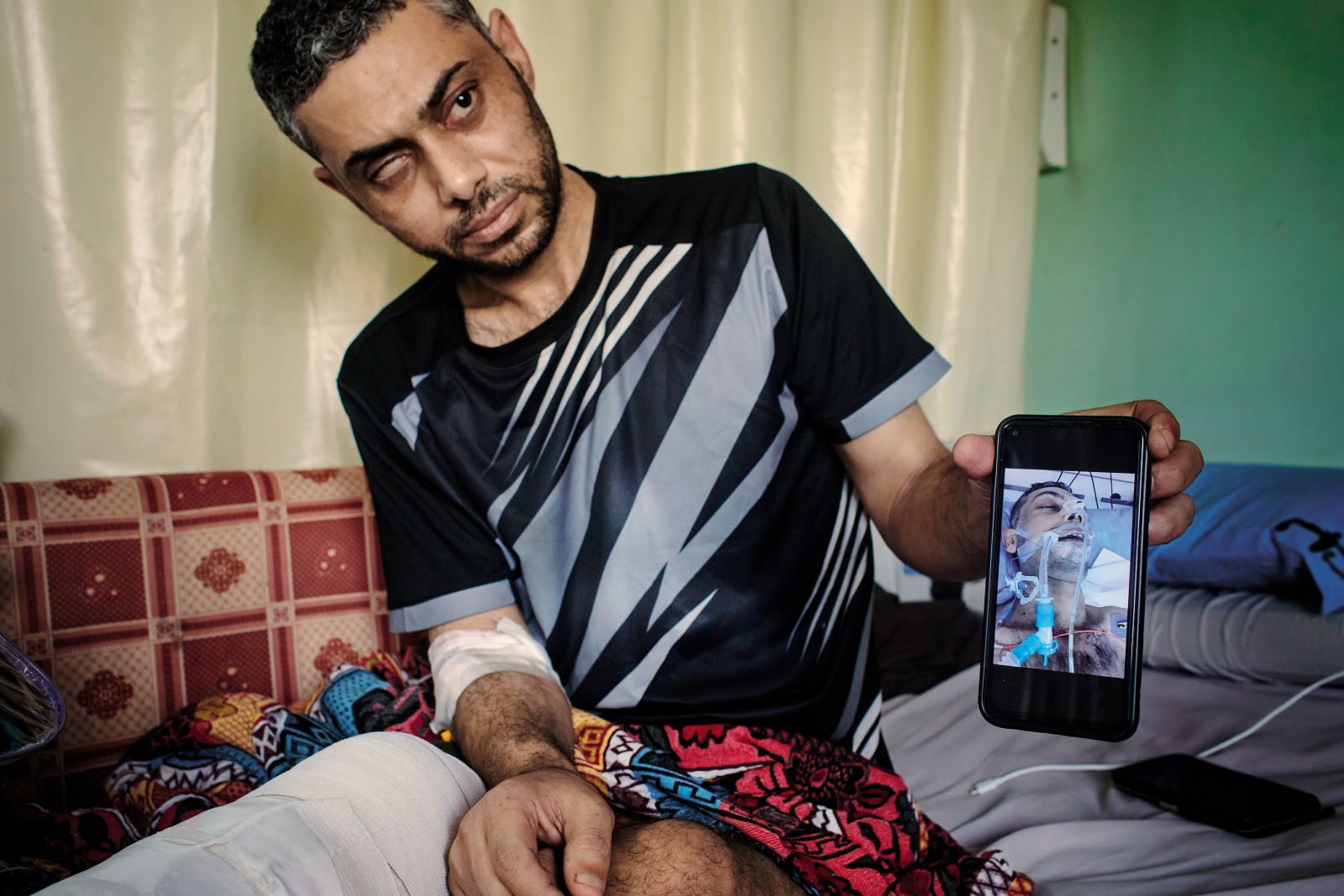Zdravnik Tamir Al Hafi (40), ki so ga izraelski vojaki mučili in mu odrekali zdravljenje, s fotografijo sebe v komi.