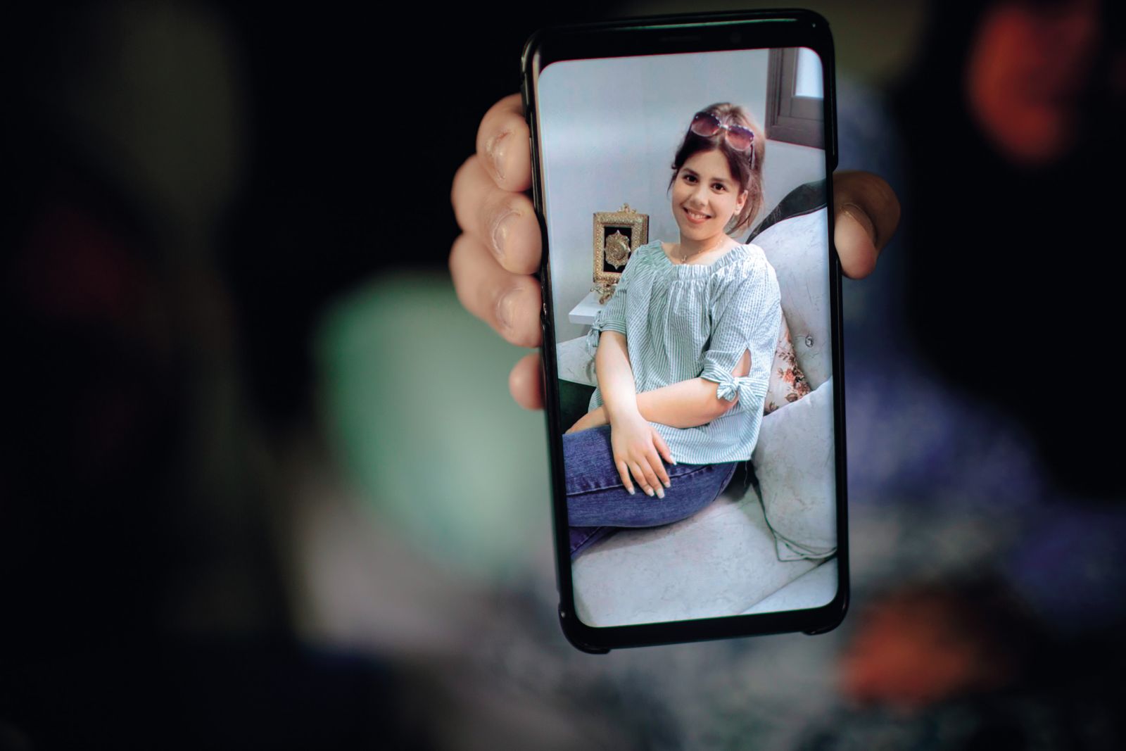 Malak Hamad (15), ki je bila ubita v izraelskem bombardiranju. Telefon drži njena mama Ala, ki je bila v napadu hudo ranjena