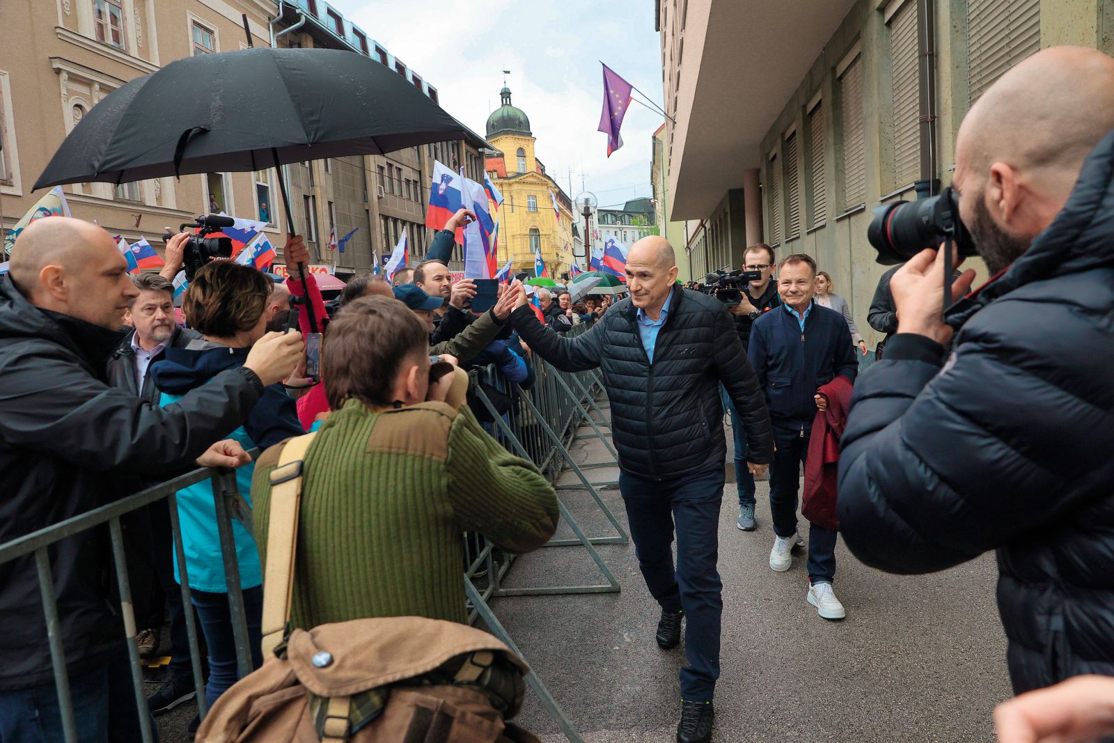 Janez Janša deli »petke« podpornikom ob prihodu na sodišče v Celju.