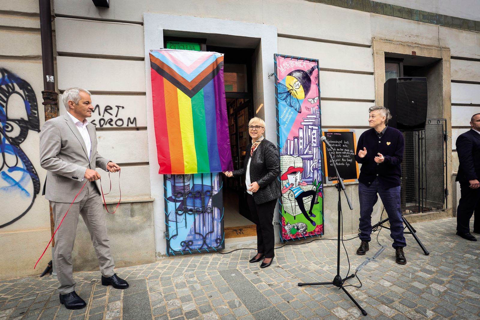 Dvig zastave pred knjigarno Mariborka v Mariboru: župan Saša Arsenovič, predsednica države Nataša Pirc Musar in pesnica Anja Zag Golob | Marko Pigac