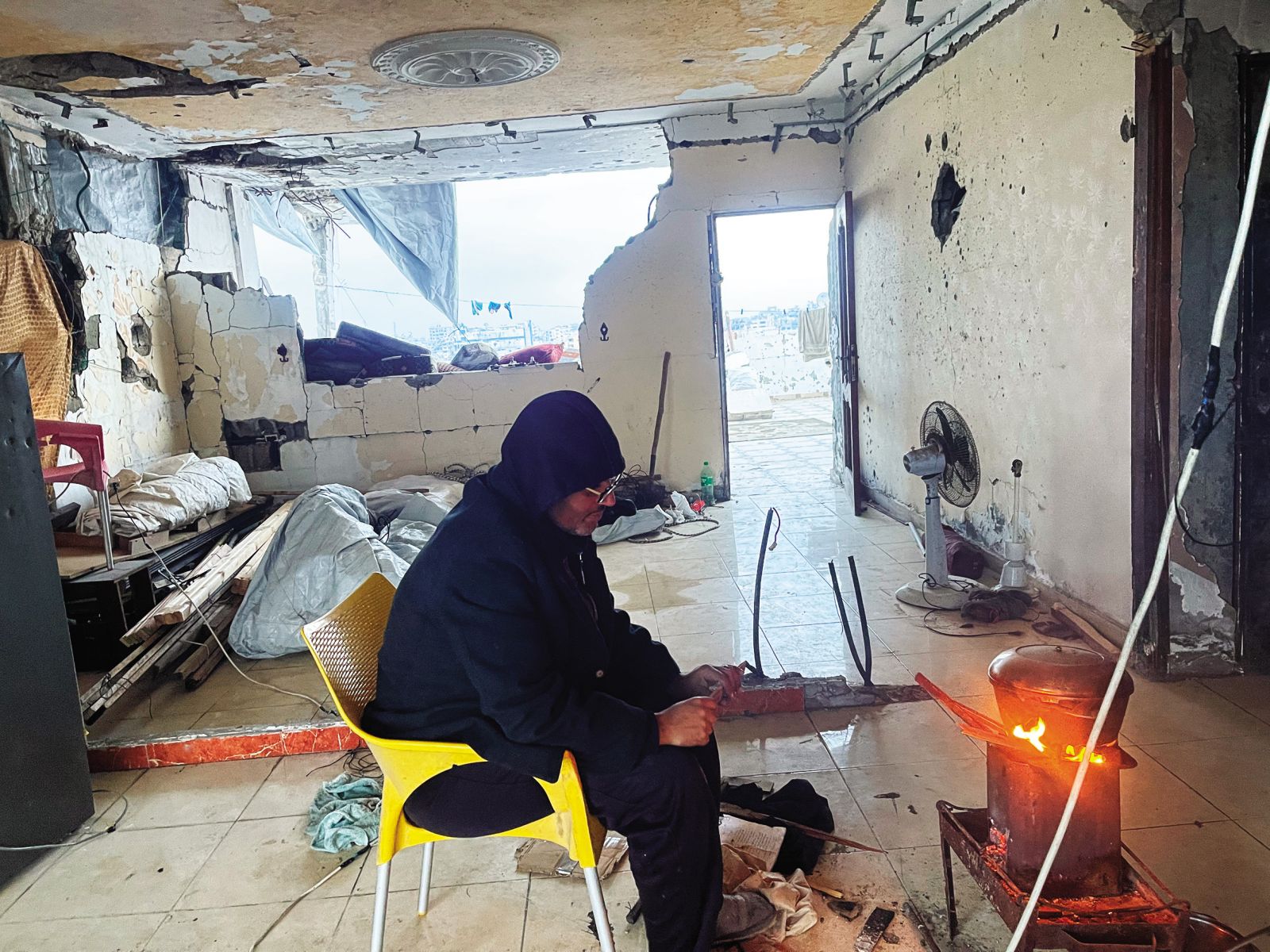 Ahmed med pripravljanjem obroka v svojem uničenem stanovanju.