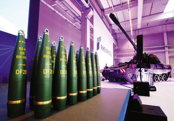 Odprtje nove tovarne artilerijskega streliva Rheinmetall 27. avgusta 2025 v Unterluessu v Nemčiji. Na fotografiji 155-milimetrska artilerijska streliva Rheinmetall (spredaj) in bojno vozilo Panzerhaubitze 2000 