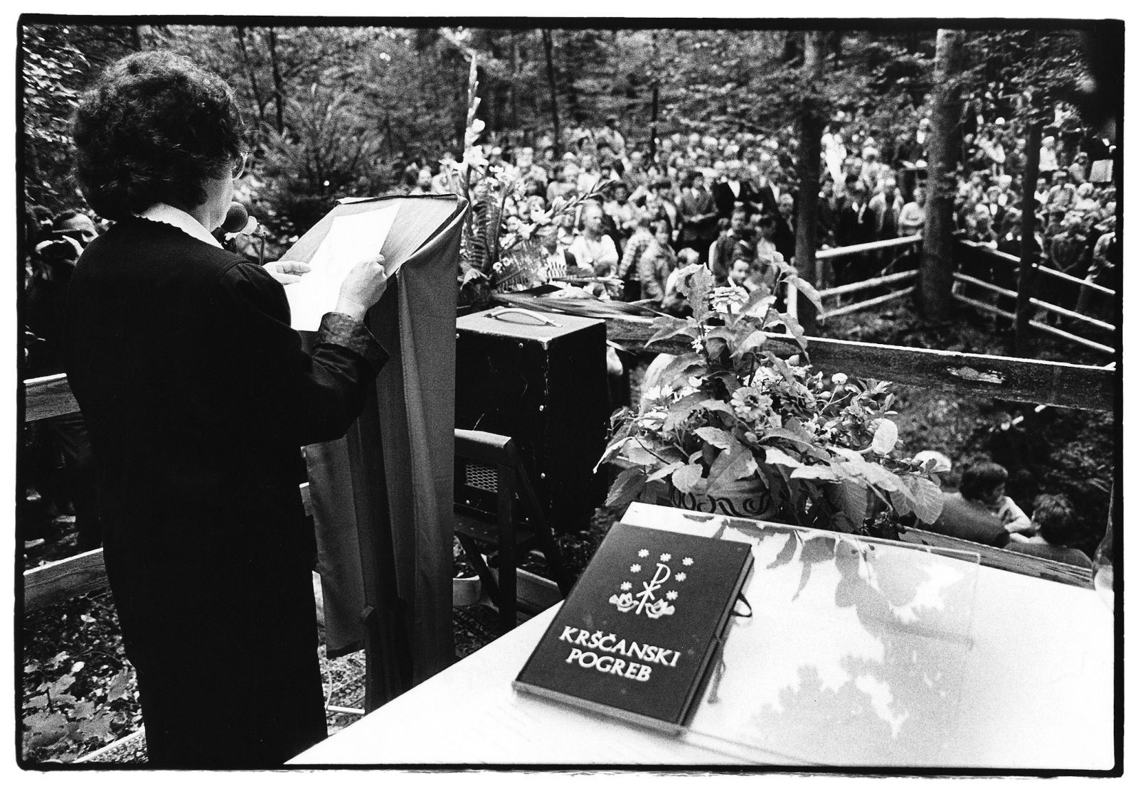 Po spravni slovesnosti so se stvari v Sloveniji znova zaostrile. Spomenka Hribar svojega prsta ne uperja le v revolucionarno stran, moti jo tudi sprenevedanje Cerkve, ki se še ni jasno opredelila in ni obsodila medvojne kolaboracije z nacifašizmom (na fotografiji nastop Spomenke Hribar med mašo pred grobiščem v Krimski jami leta 1990).