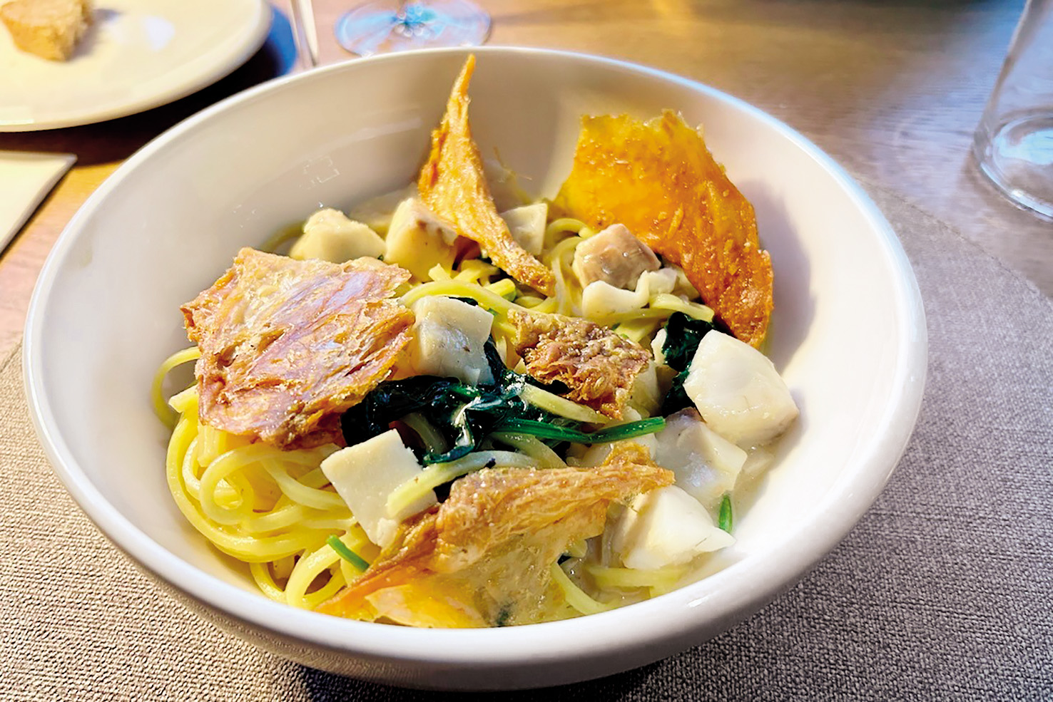 Špageti z brancinom in piščančjo kožo