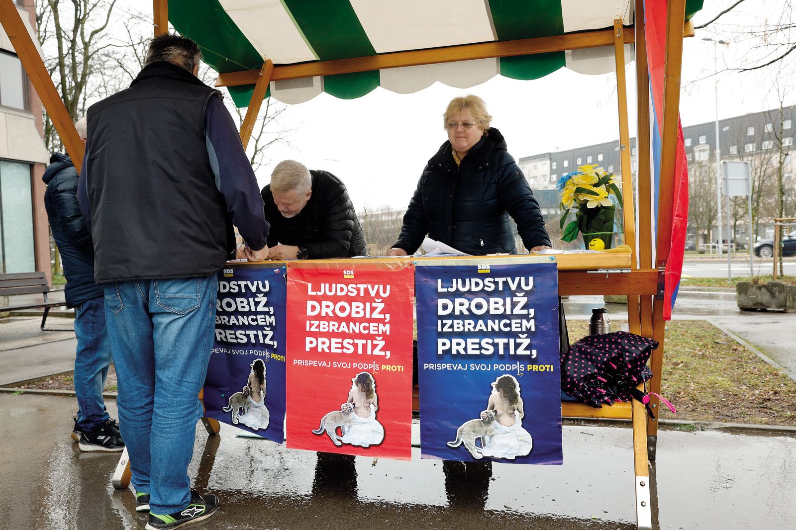 Zbiranje podpisov za referendum o dodatku k pokojnini za izjemne umetniške dosežke. Na propagandnem plakatu je reproducirana fotografija umetniškega dela Maje Smrekar Hibridna družina. To je očitna politična zloraba umetnosti in umetnice.