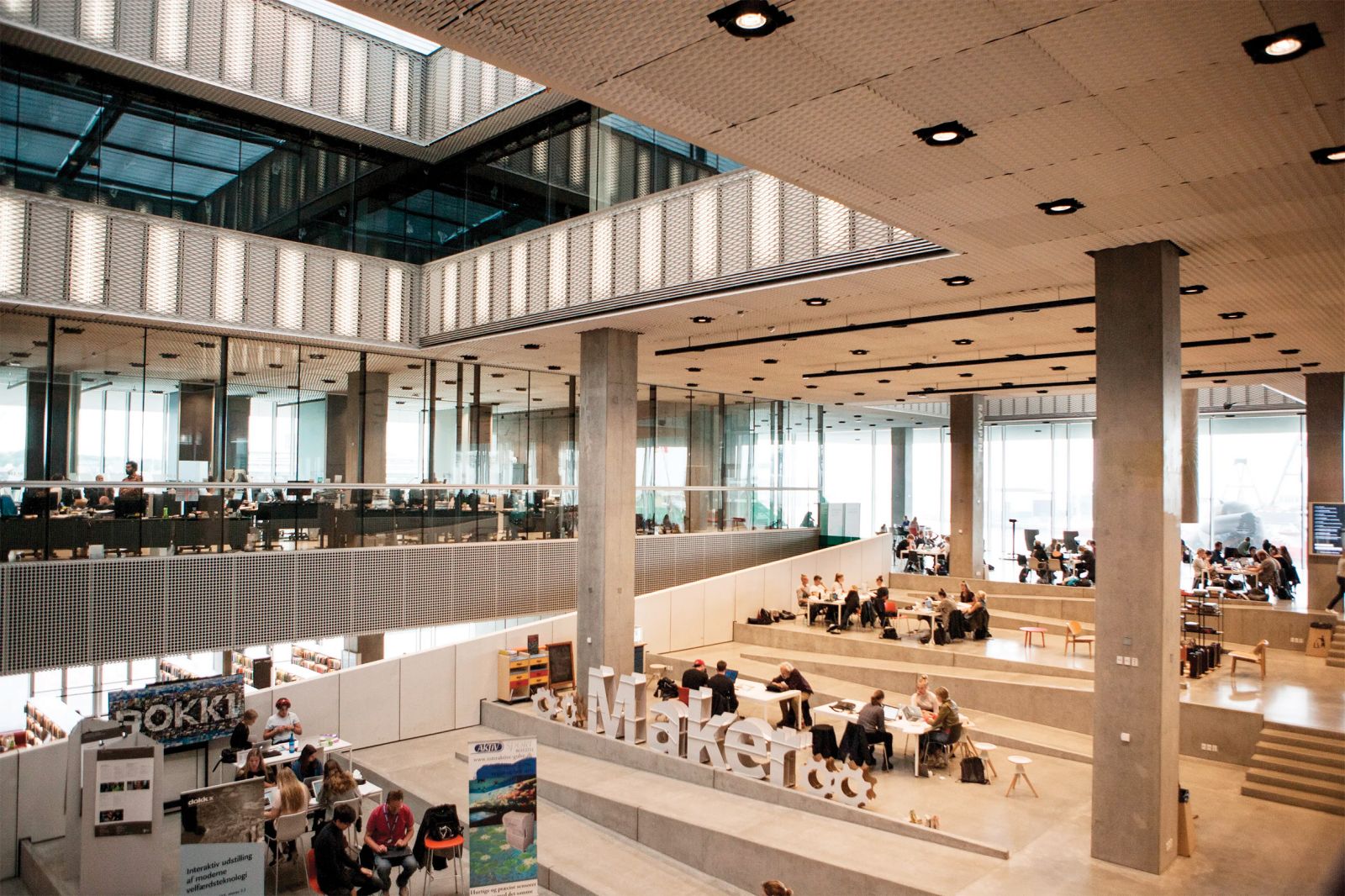 Dokk1 ni tiha knjižnica, arhitekti Schmidt Hammer Lassen Architects so jo zasnovali tako, da bi se uporabniki v njej lahko družili – kot da bi se srečevali na pokritem mestnem trgu.