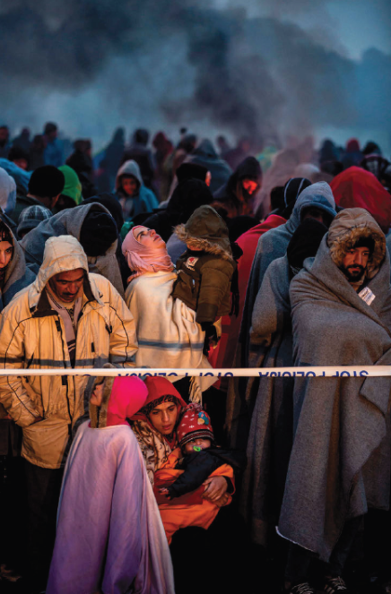 Osrednja monumentalna fotografija cikla Pot (2015–2018) z množico beguncev, sredi katere mati z otrokom spominja na svetopisemsko podobo Marije z malim Jezusom.