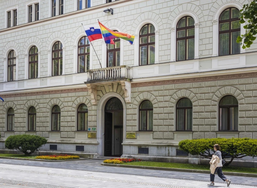 Mavrična zastava ob boku slovenski na predsedniški palači v Ljubljani. 
