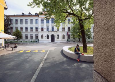 Prenovljeni trg pred glavnim vhodom v Gimnazijo Poljane, ki so ga z izravnavo površin in novo tlakovno zasnovo povezali z okolico. Obogaten je z elementi v obliki prodnikov, ki se pojavljajo tudi v notranjem atriju.