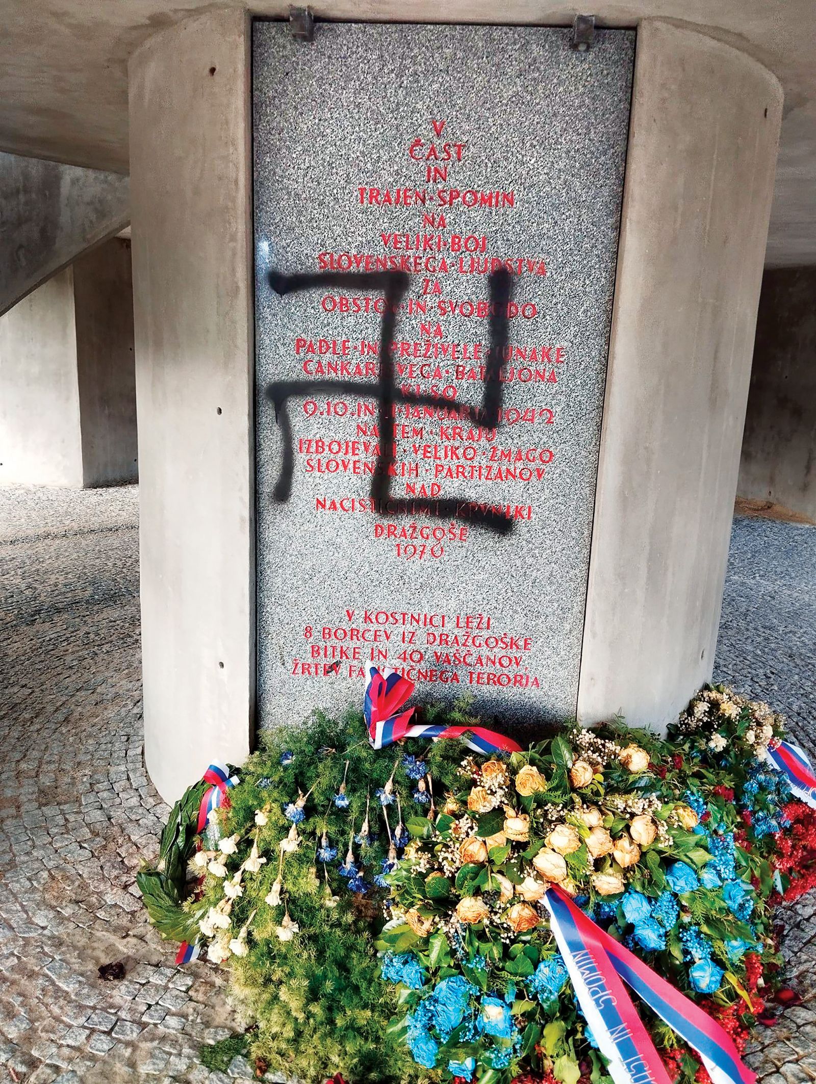 Svastika na spomeniku v Dražgošah. Ne gre samo za uničenje spomenika državnega pomena, gre tudi za skrunitev grobnice, saj so tam pokopani partizani in vaščani, ki jih je pobila nemška vojska.