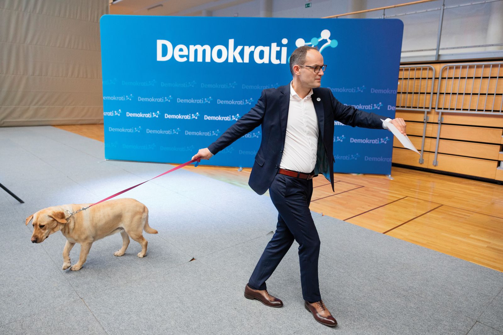 Anže Logar je na dogodek v Logatcu pripeljal tudi labradorko Dono. S tem naj bi odgovoril na naslovnico Demokracije, ki ga je pred kratkim upodobila kot zlatega prinašalca, domnevno predanega Robertu Golobu.