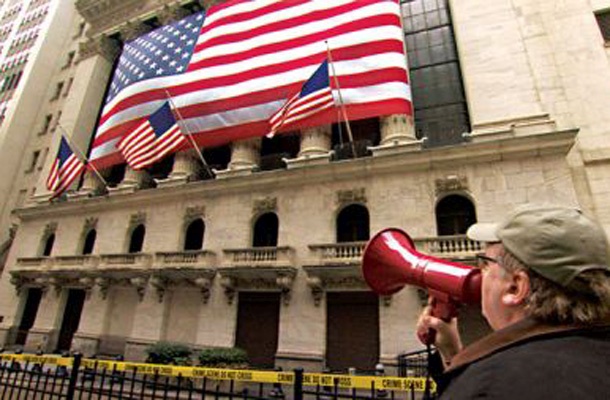 Režiser Michael Moore v dokumentarcu Kapitalizem: ljubezenska zgodba nagovarja globalne simbole izkoriščanja.