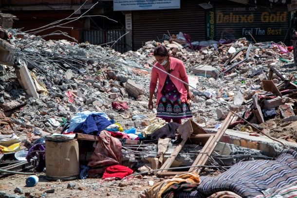 Ženska brska med ostanki svojega doma v zahodnem Katmanduju