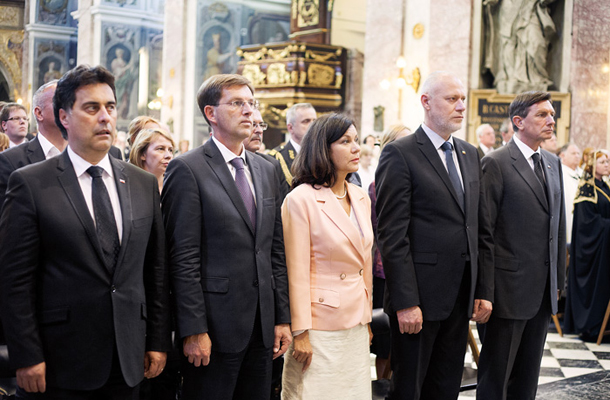 Pred dvema letoma. Prva vrsta pri maši za domovino. Predsednik državnega sveta Mitja Bervar, premier Miro Cerar (SMC) in njegova spremljevalka Vesna Arnšek, predsednik državnega zbora Milan Brglez (SMC) in predsednik republike Borut Pahor (SD).