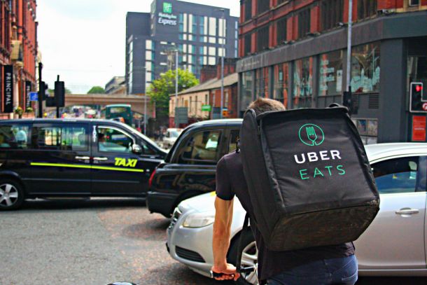 Dostavljalec hrane Uber Eats na kolesu med gnečo v britanskem Manchestru