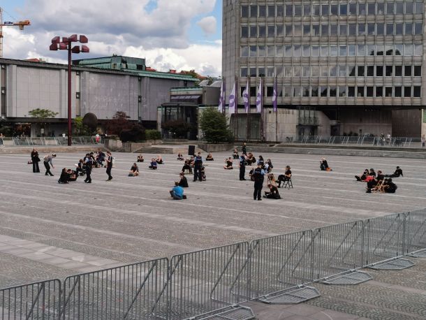 Protesniki še pred uradnim začetkom protestov berejo Ustavo RS v ograjenem delu Trga republike